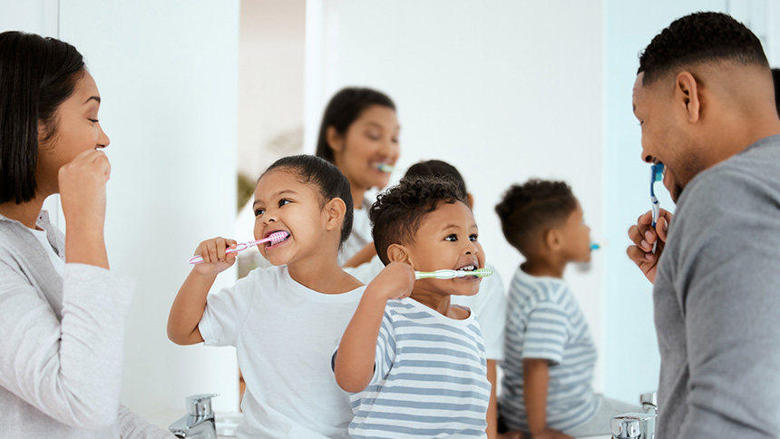 Nio y Nia Cepillndose los Dientes en Compaa de sus Padres